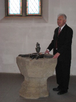 Pfarrer Stehle am Taufstein in Oferdingen